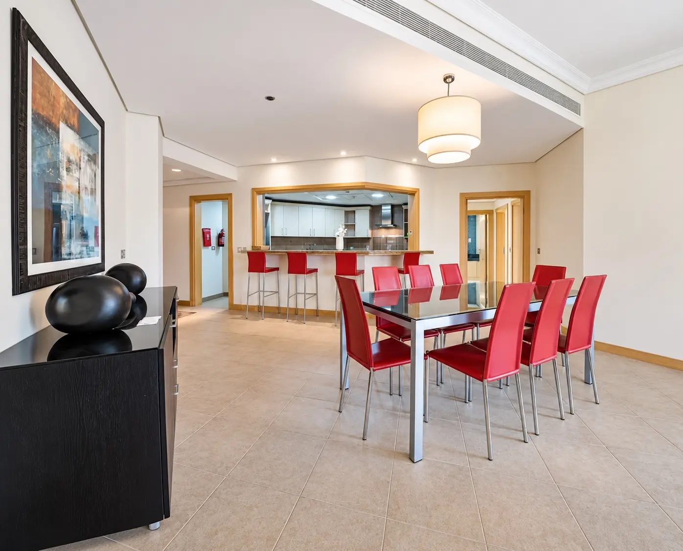 Original dining area with red chairs and basic finishes