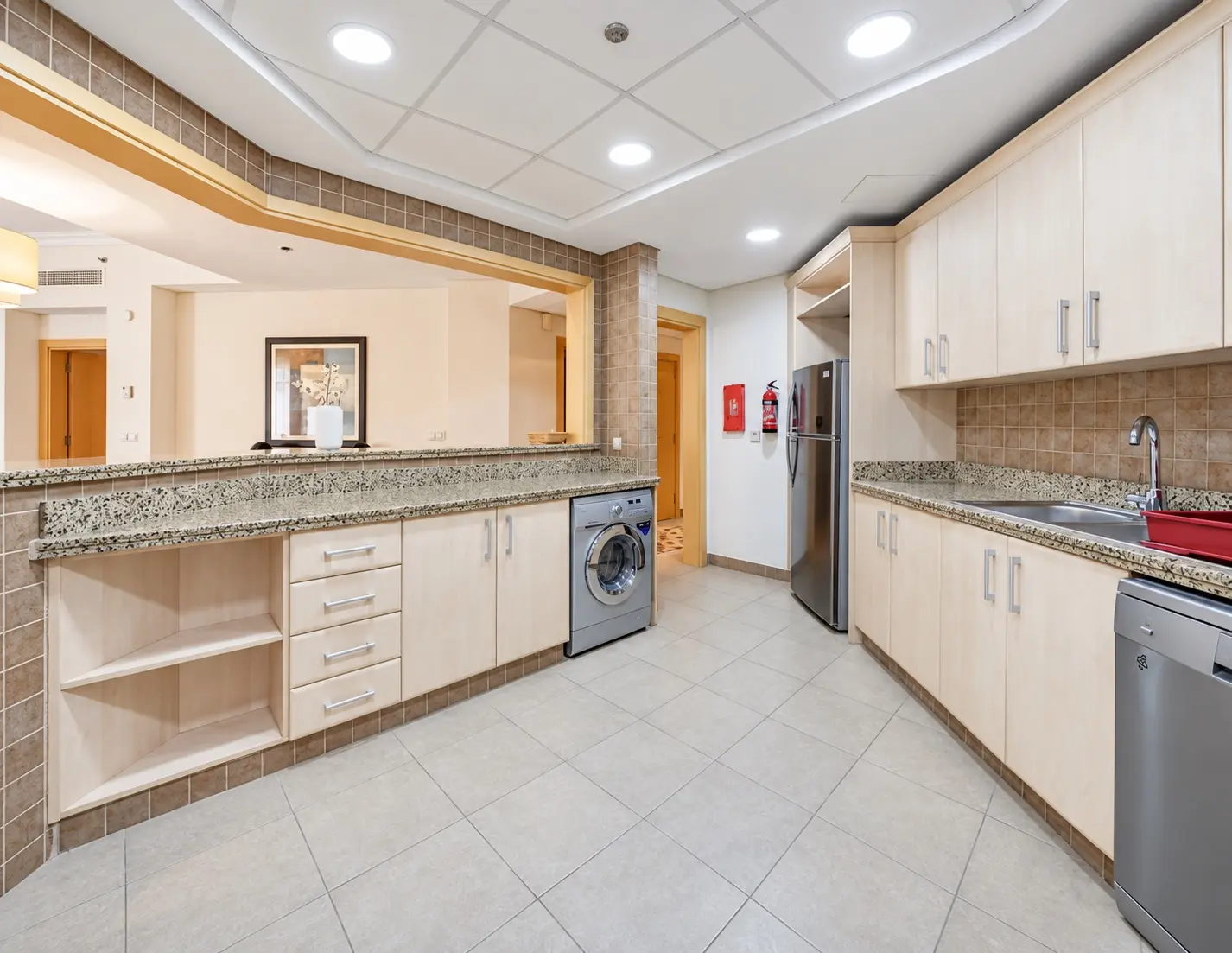 Original kitchen with pale cabinets, tiled splashback and exposed appliances