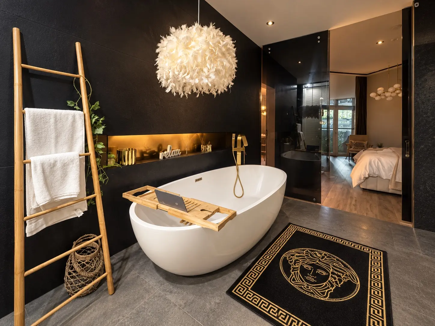 Renovated master bathroom with freestanding bath and black stone feature wall