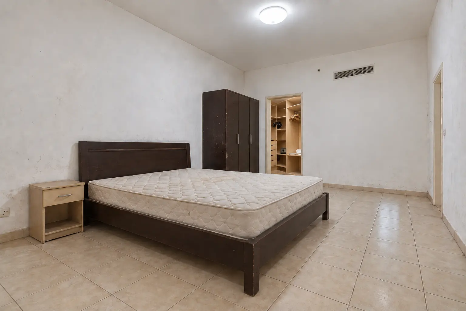 Reconstructed master bedroom before renovation with a closed wall and original wardrobe visible through the retained doorway