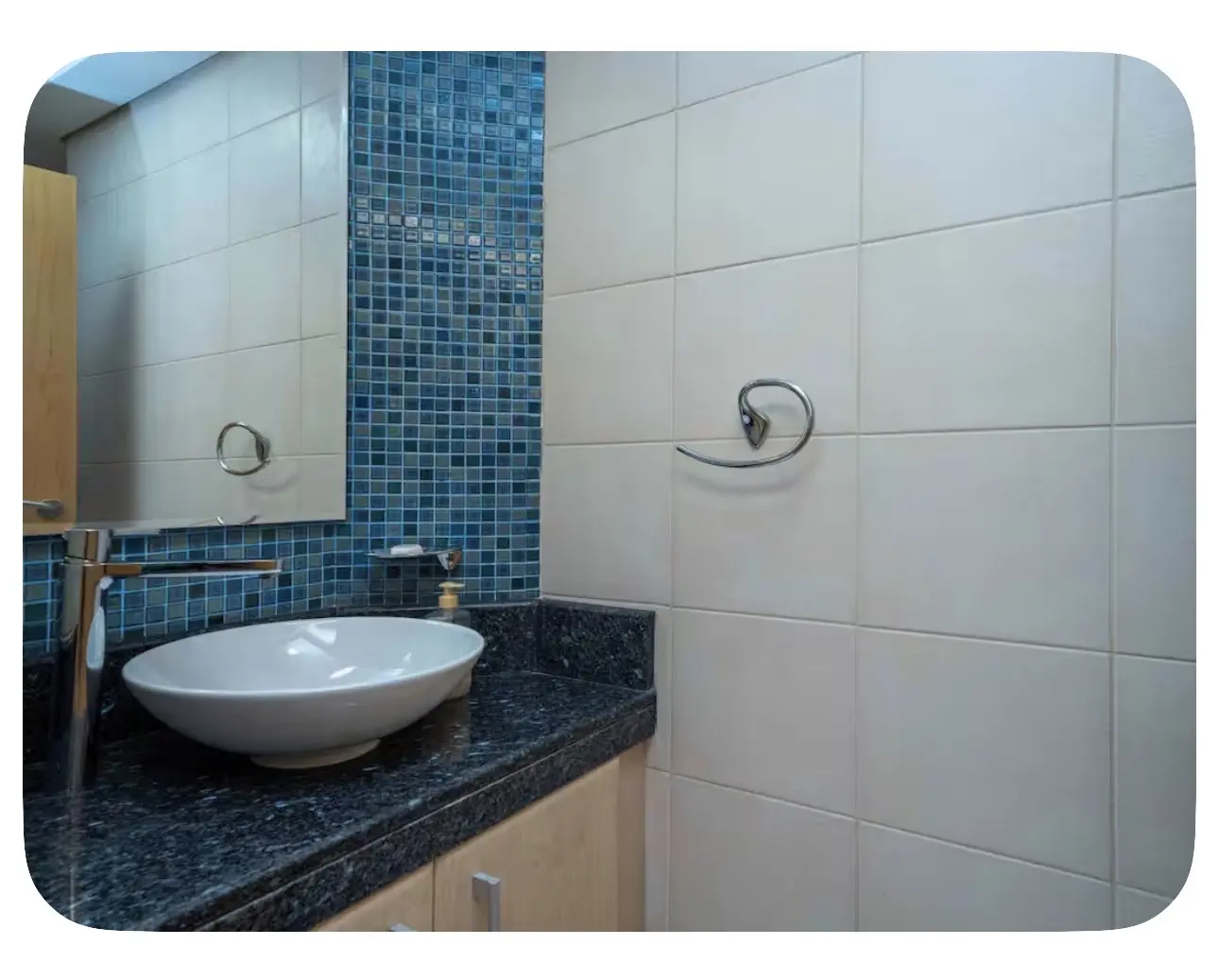 Original bathroom vanity with blue mosaic accent wall and single basin